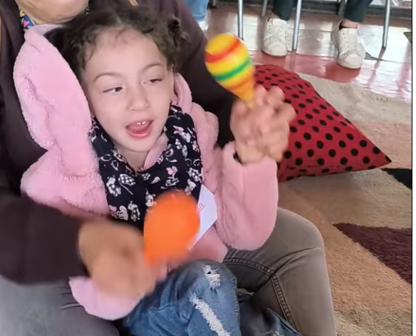 niña tocando las maracas